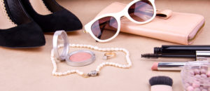 Beautiful set of women's fashion accessories and cosmetics on a beige background