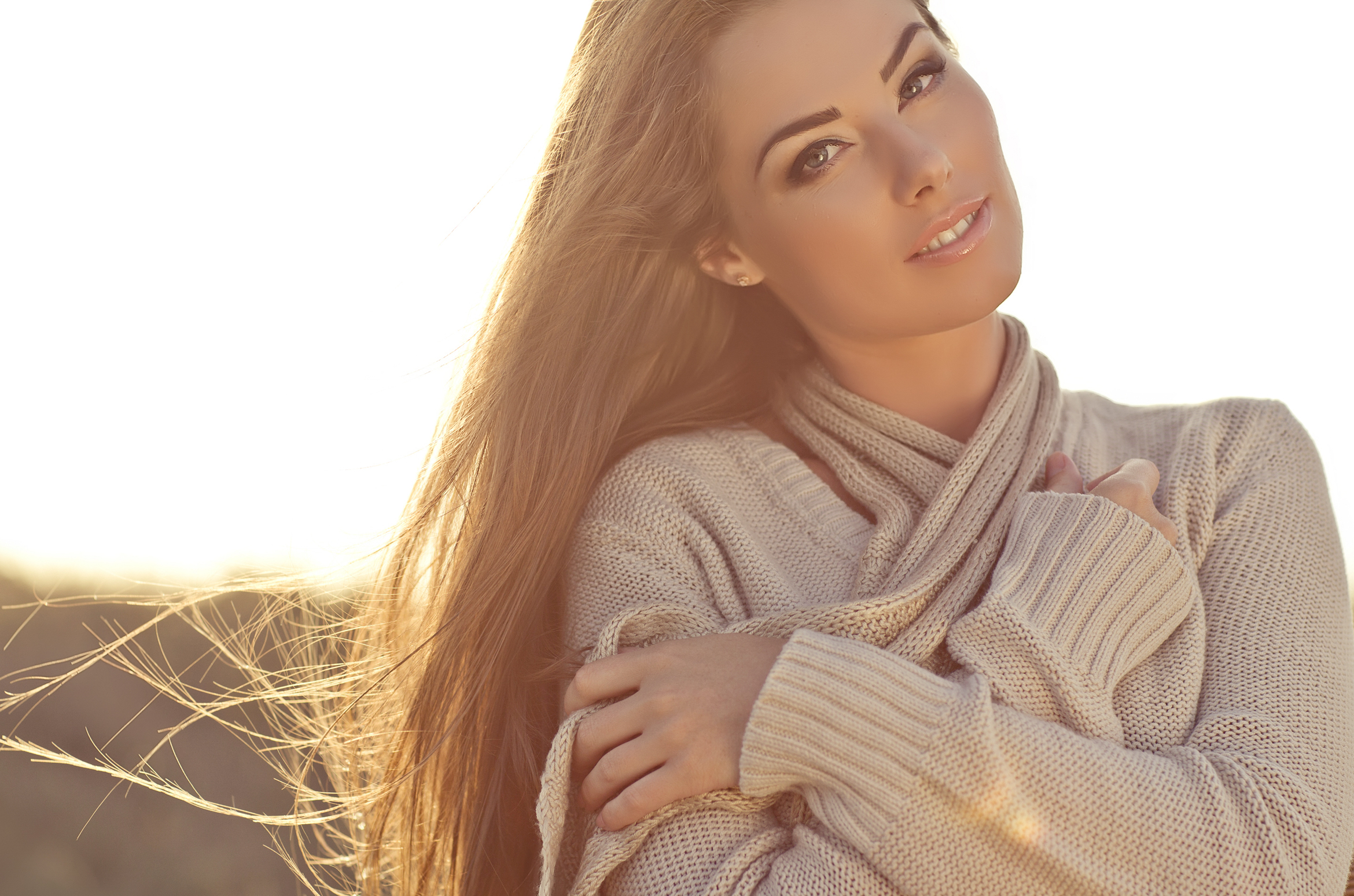 Beautiful young woman in sweater, hugging it close